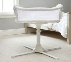 a white crib sitting on top of a wooden floor