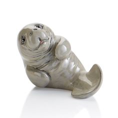 a glass seal bear figurine sitting on its side with it's mouth open