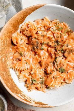 a bowl filled with pasta and sauce on top of a table