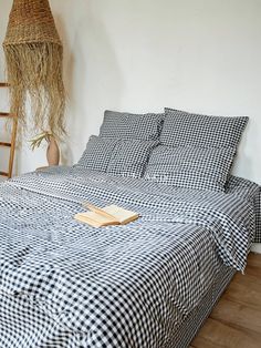 a black and white checkered bedspread on a wooden floor with a basket hanging above it