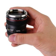 a person holding a camera lens in their hand