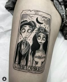 the lovers tarot card tattoo on the right thigh is black and white, with an image of two people