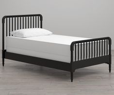 a black bed frame with white sheets and pillows