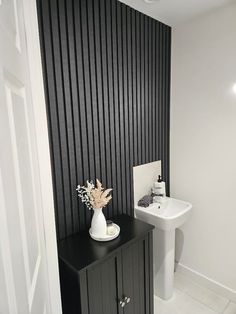 a white sink sitting next to a black cabinet