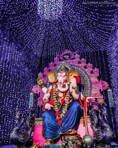 the statue of lord ganesh is surrounded by purple and white lights in this photo