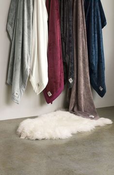 several towels hanging on the wall next to a sheepskin rug