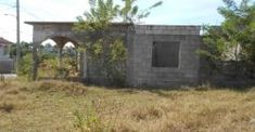 an old building sitting in the middle of a field