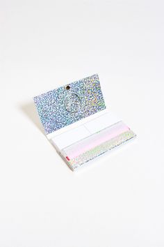 a card with glitter on it sitting on top of a white table next to a pair of scissors