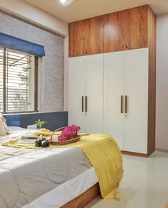 a bed room with a neatly made bed and cupboards