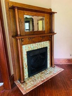 a fireplace with a mirror above it in a room that has wood floors and walls