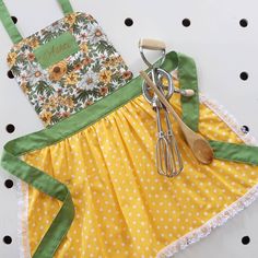 an apron and utensils are sitting next to each other on a polka dot tablecloth