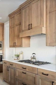 a kitchen with wooden cabinets and white counter tops, along with a stove top oven