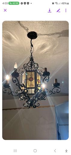 a chandelier hanging from the ceiling in a room with white walls and ceilings