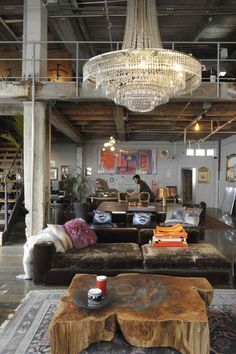 a living room filled with furniture and a chandelier hanging over the top of it