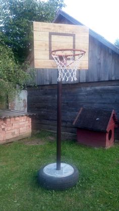 a basketball hoop is in the yard next to a dog house