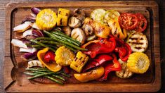 a wooden cutting board topped with assorted veggies