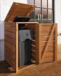 a wooden trash can sitting on top of a hard wood floor next to a window