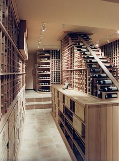 a wine cellar filled with lots of bottles and wooden shelves on either side of the room