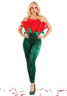 a woman in green velvet pants and red top with roses on her chest, posing for the camera