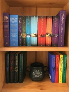 a book shelf filled with lots of books next to a potted plant on top of it