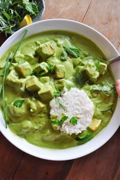 a white bowl filled with green food and rice