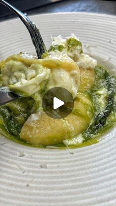 a white plate topped with pasta and broccoli covered in cheese sauce next to a fork