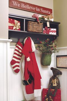 christmas stockings and gifts are hanging on the wall next to a shelf with santa's stocking