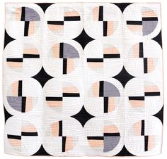 a black and white quilt hanging on a wall