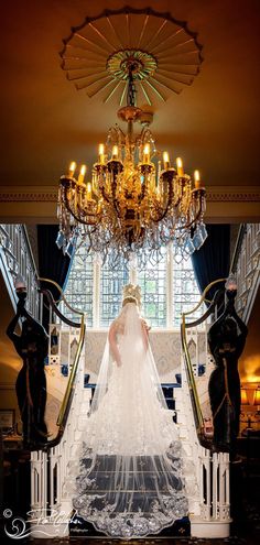 the bride is walking down the stairs in her wedding dress