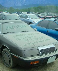 a parking lot full of parked cars with writing on the hood