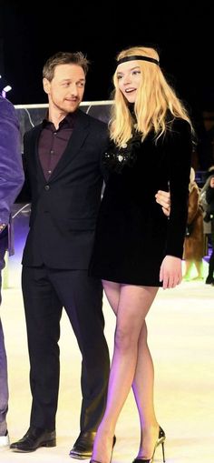 a man and woman standing next to each other on an ice skating rink at night