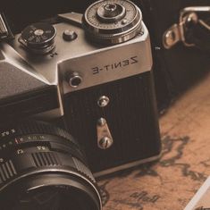 an old fashioned camera sitting on top of a wooden table