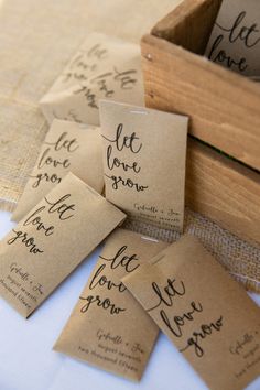 some brown paper tags with writing on them and one has a wooden box in the middle