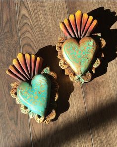 two decorative heart shaped cookies sitting on top of a wooden table next to each other