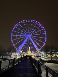 the ferris wheel is lit up at night