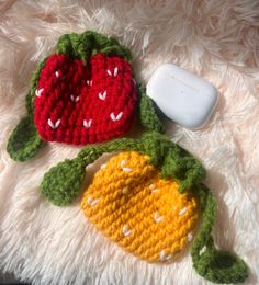 two crocheted fruits are laying on a white blanket next to a computer mouse