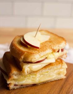 two grilled cheese sandwiches stacked on top of each other with apple slices and toothpicks