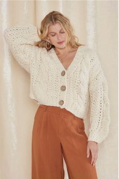 Stay cozy with our ultra soft cable knit cardigan - the perfect staple for your fall and winter wardrobe. Style #R4398-23AM-11 Trendy V-neck Cable Knit Cardigan, Cream Cable Knit Sweater Coat For Fall, Fall Cream Cable Knit Outerwear, Elegant Beige Cable Knit Cardigan, Trendy Cable Knit Cream Outerwear, Trendy Cream Cable Knit Outerwear, Cream Textured Knit Cardigan For Fall, Cable Knit V-neck Sweater For Layering, Fall Cream Textured Knit Cardigan