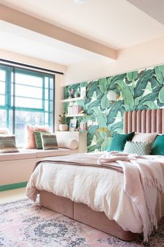 a bedroom with green and white wallpaper on the walls, a bed in front of a window