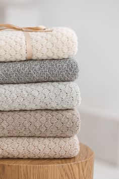 a stack of folded towels sitting on top of a wooden table