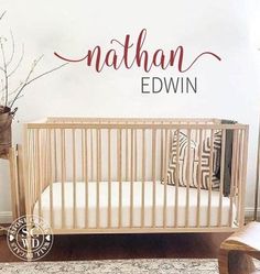 a baby crib with the name nathan edwin in red on it's wall