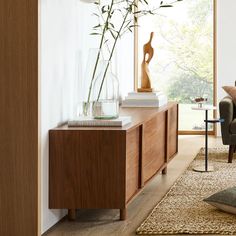 a living room with a couch, chair and vase filled with flowers on the table