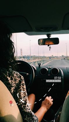 two people in a car driving down the road with their hands on the steering wheel