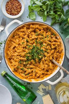 a large pot filled with macaroni and cheese on top of a table next to other ingredients