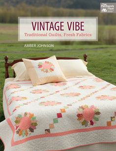 an old fashioned bed in the grass with pillows on it and a quilted bedspread