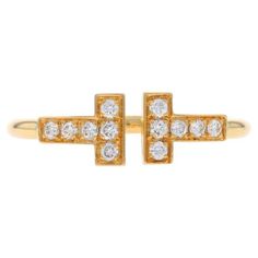 Retail Price: $2,675 Size: 6 1/2 Brand: Tiffany & Co. Collection: T Design: Wire Ring Metal Content: 18k Yellow Gold Stone Information Natural Diamonds Carat(s): .13ctw Cut: Round Brilliant Color: E - F Clarity: VS1 - VS2 Total Carats: .13ctw Center Opening (east to west): 1.1mm Style: Negative Space Band Measurements Face Height (north to south): 1/4" (5.8mm) Rise Above Finger: 3/32" (2mm) Weight: 2.7 Grams Stamps: AU 750, T & Co., copyright symbol, Italy Condition: Pre-Owned Professionally cleaned, polished, and tested to guarantee metal content. Copyright Symbol, T Design, Louis Comfort Tiffany, Wire Ring, Japan Design, Wire Rings, La Face, Tiffany And Co, Gold Stone