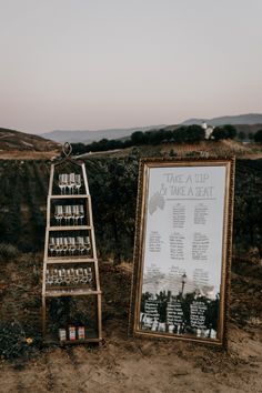 a sign with wine glasses on it next to a wooden frame and an empty glass holder