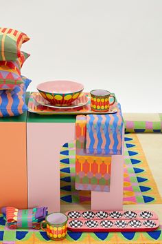 a table topped with colorful plates and cups