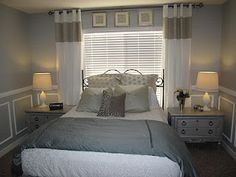 a bedroom with a bed, nightstands and two lamps on either side of the window