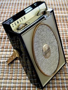 an old fashioned radio sitting on top of a woven tablecloth covered floor next to a magazine holder